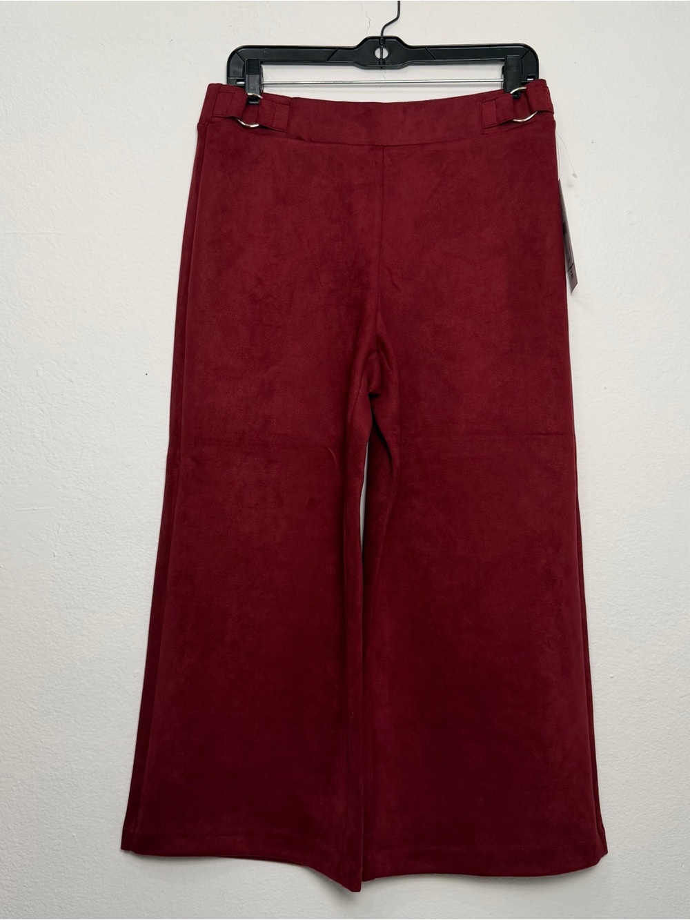 Burgundy faux-suede wide-leg pants featuring metallic side buckles.